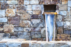A fountain of water in a stone wall.