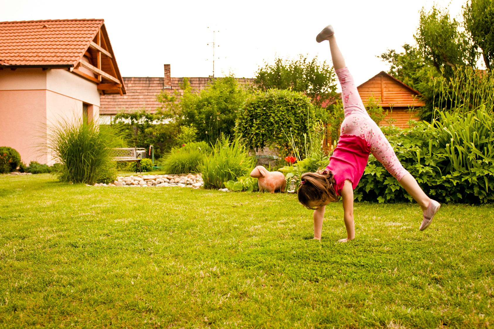 Girl doing a cartwheel in the yard