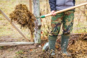 A man clears dead foliage from his garden