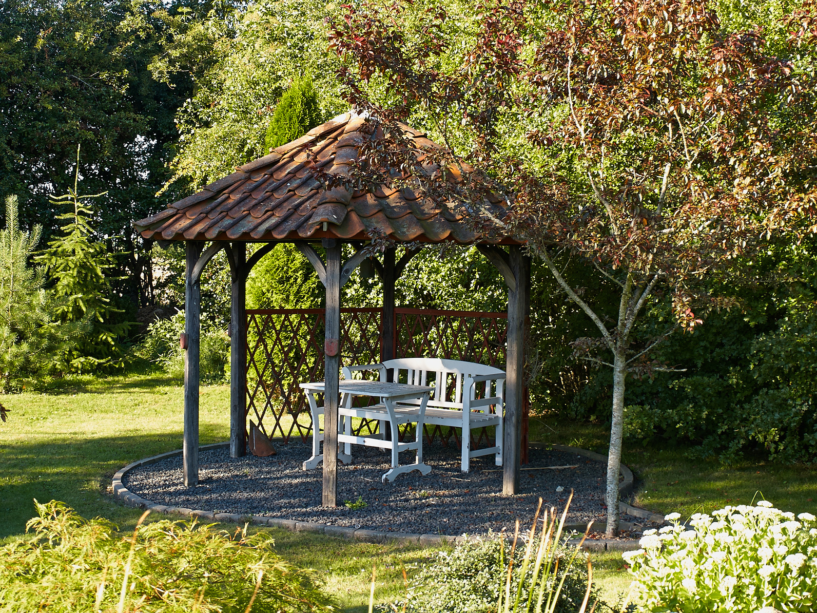 A wooden gazebo under some trees