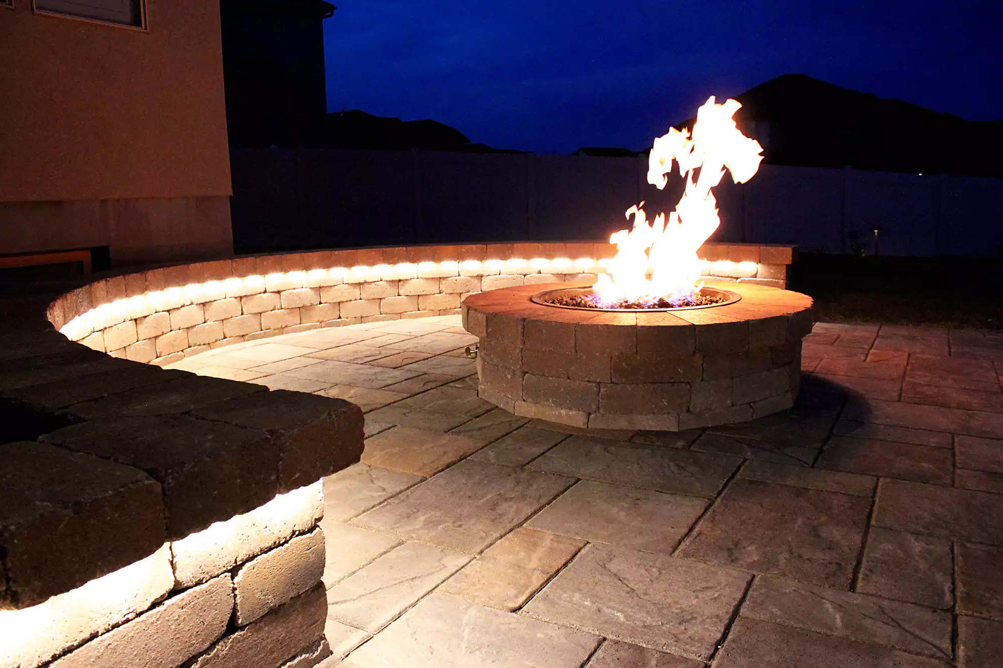 firepit surrounded by seating and built in lighting