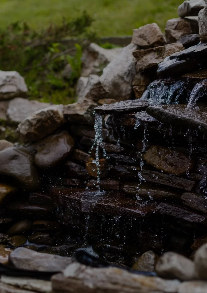 Water flowing down a backyard waterfall feature