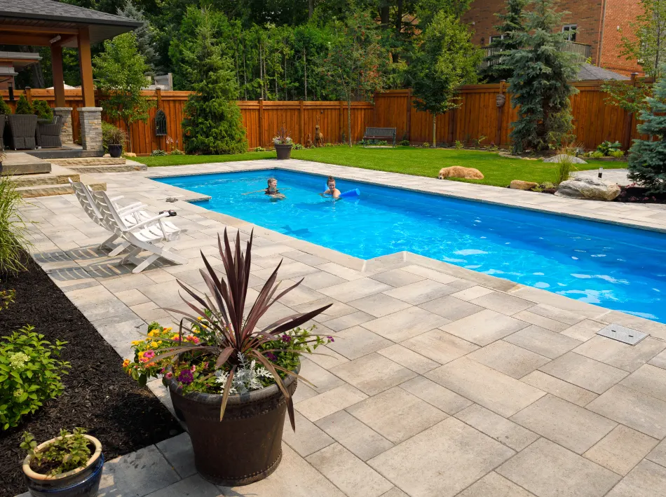 Kids playing in their backyard swimming pool