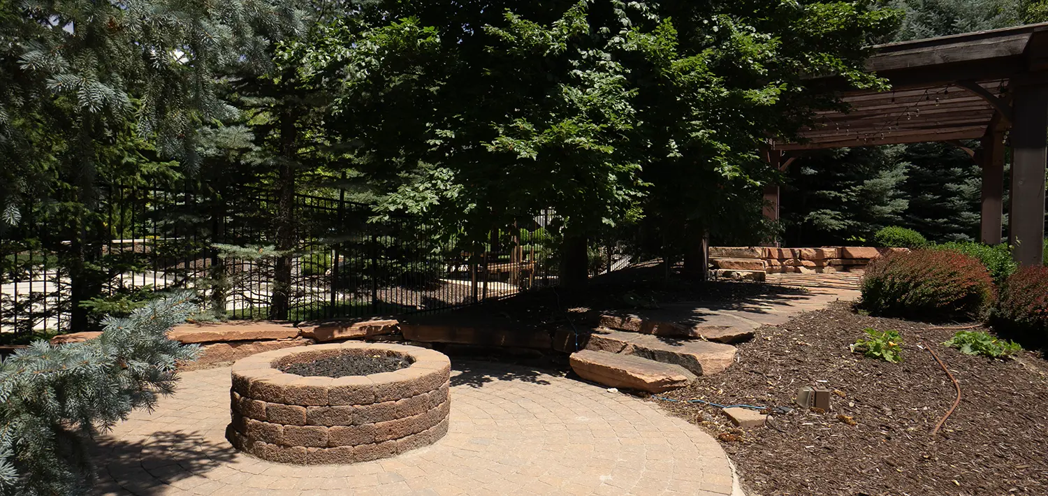 Backyard firepit surrounded by paver patio