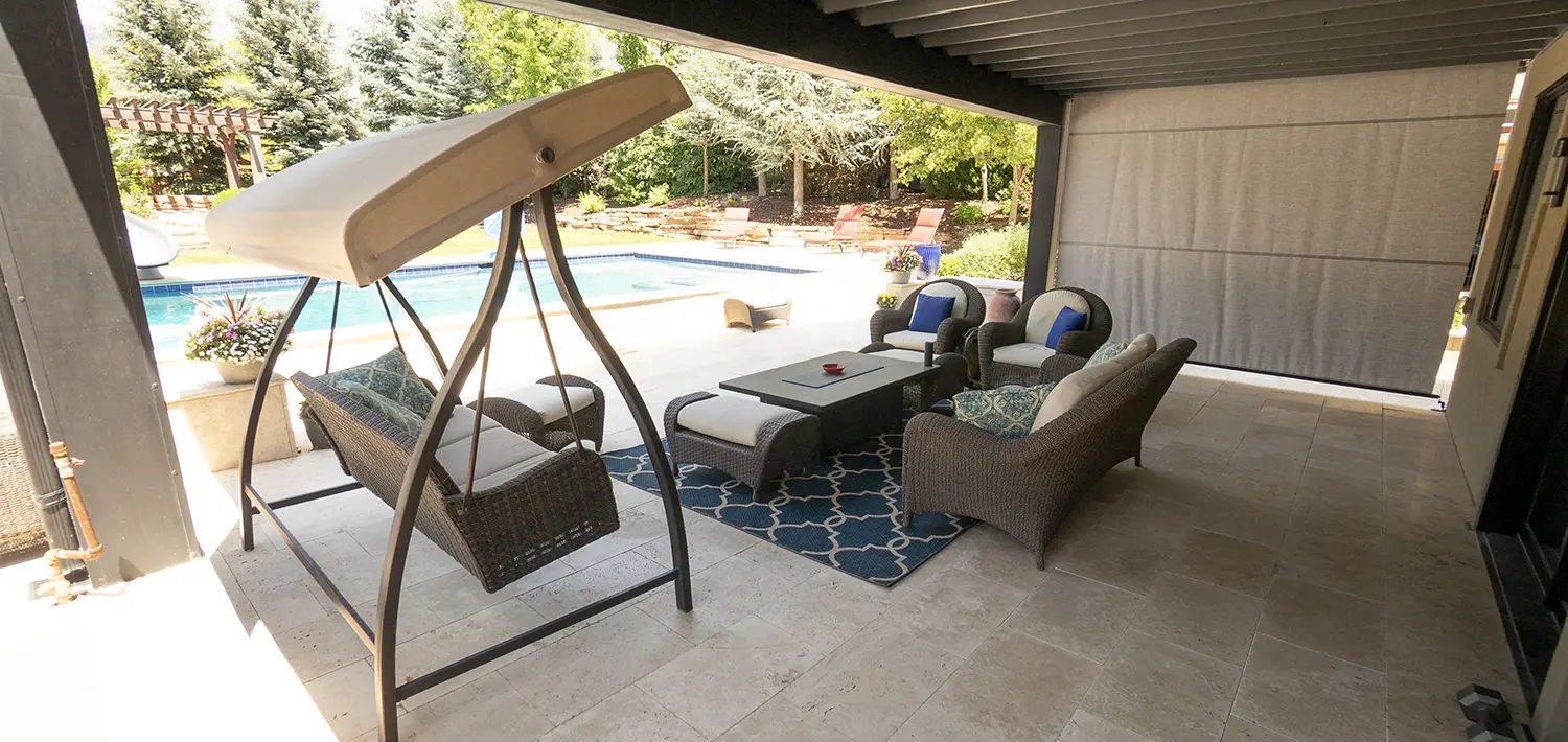 Covered patio with an outdoor living room next to the pool