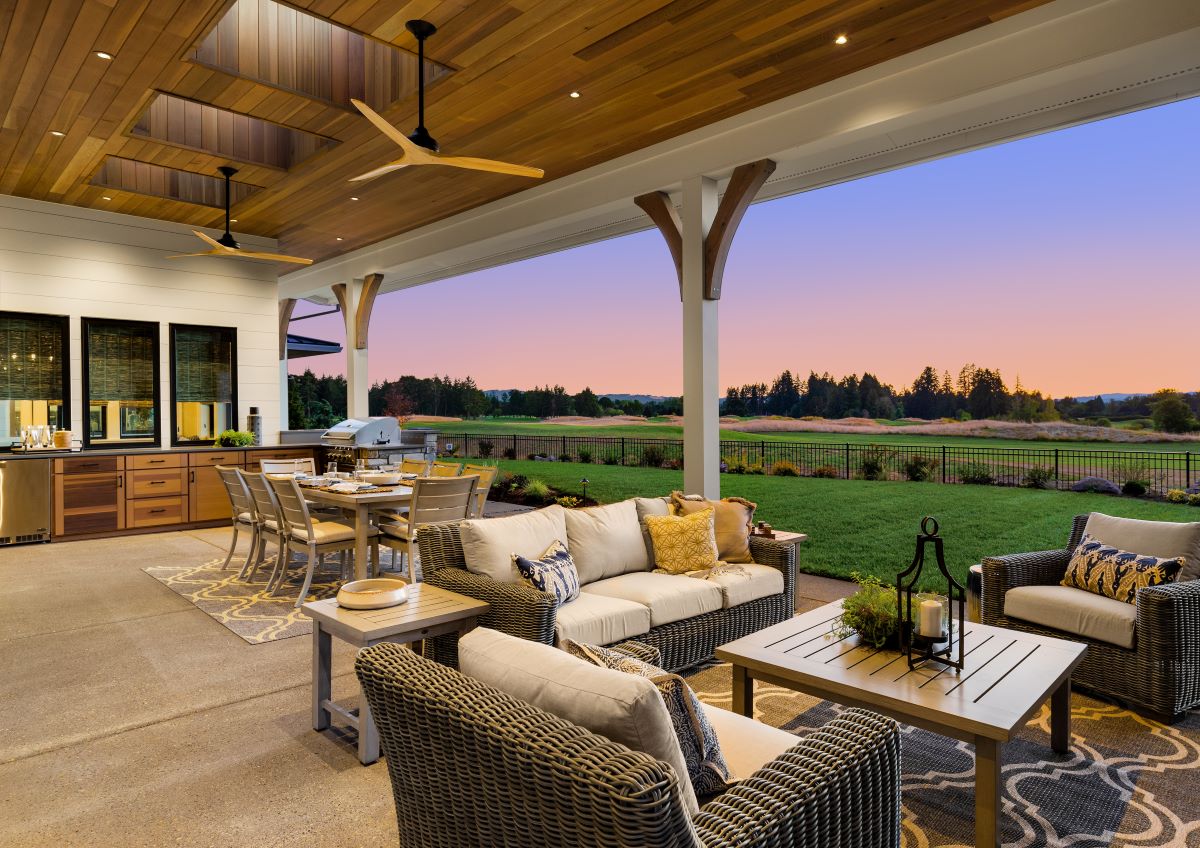 A patio with a seating area, a dining table, and an outdoor kitchen.