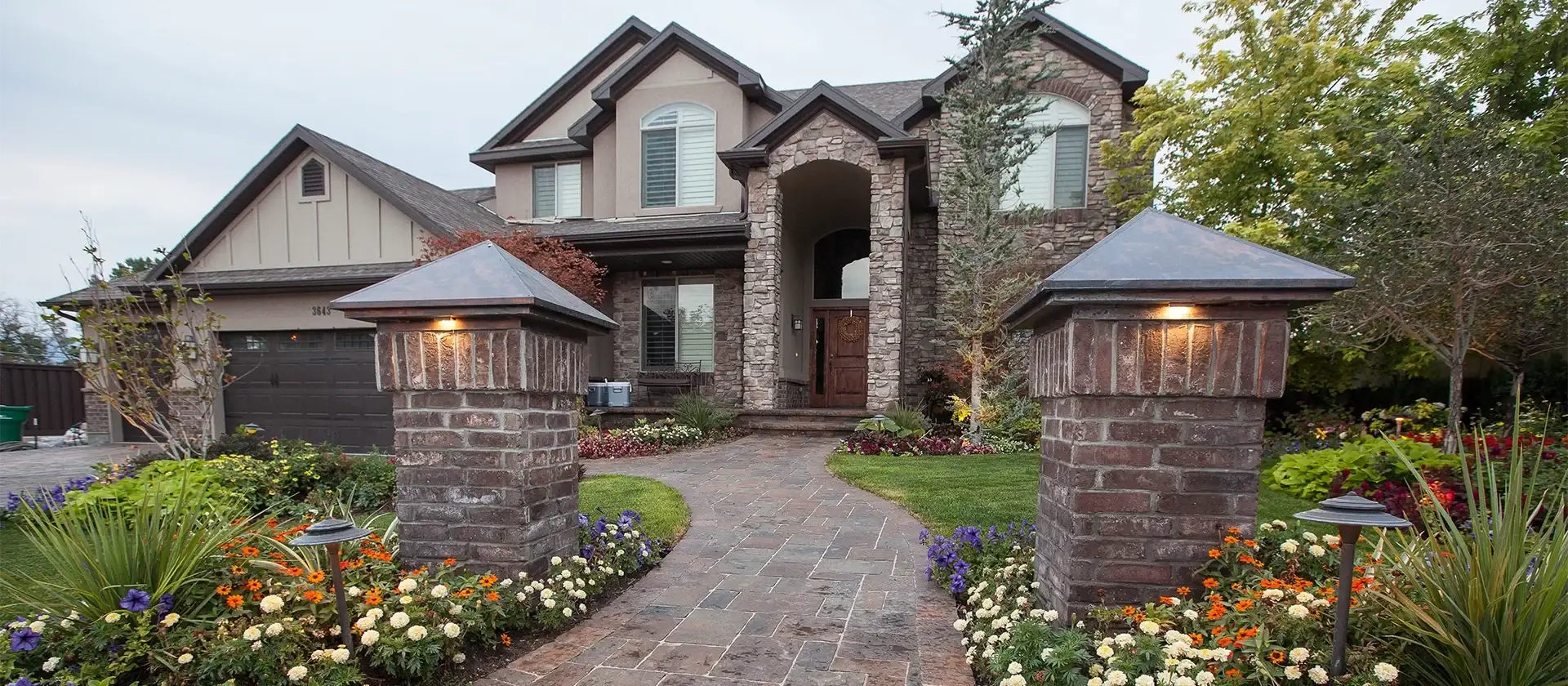 a beautiful paver walkway leads to a luxury home