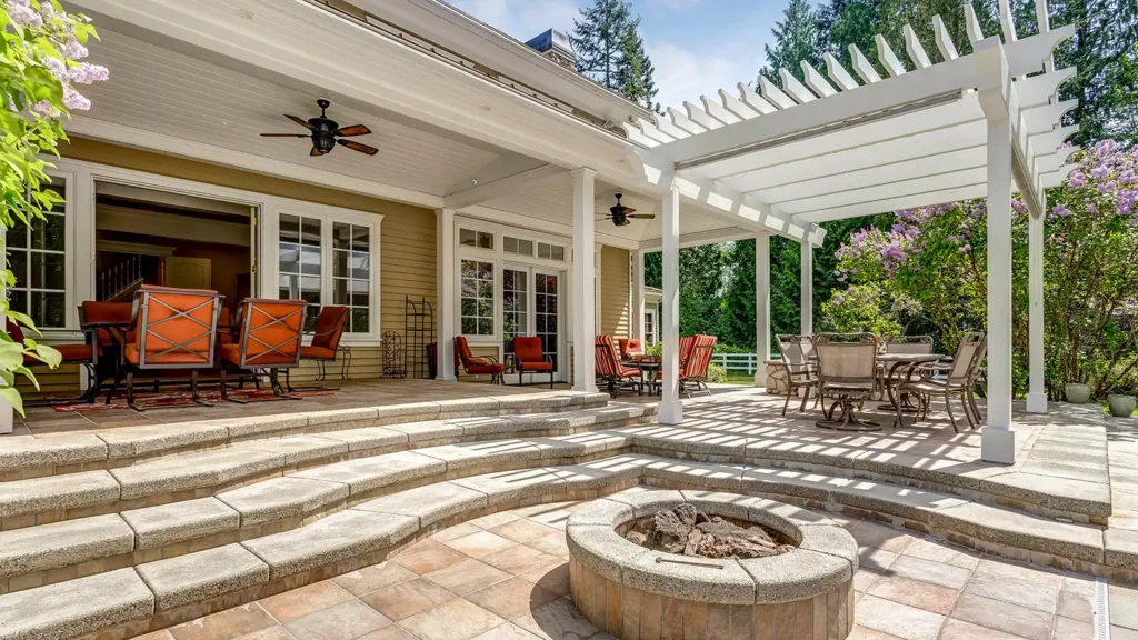 Utah landscape design that includes outdoor deck and patio space with white pergola, fire pit, pavers, and seating